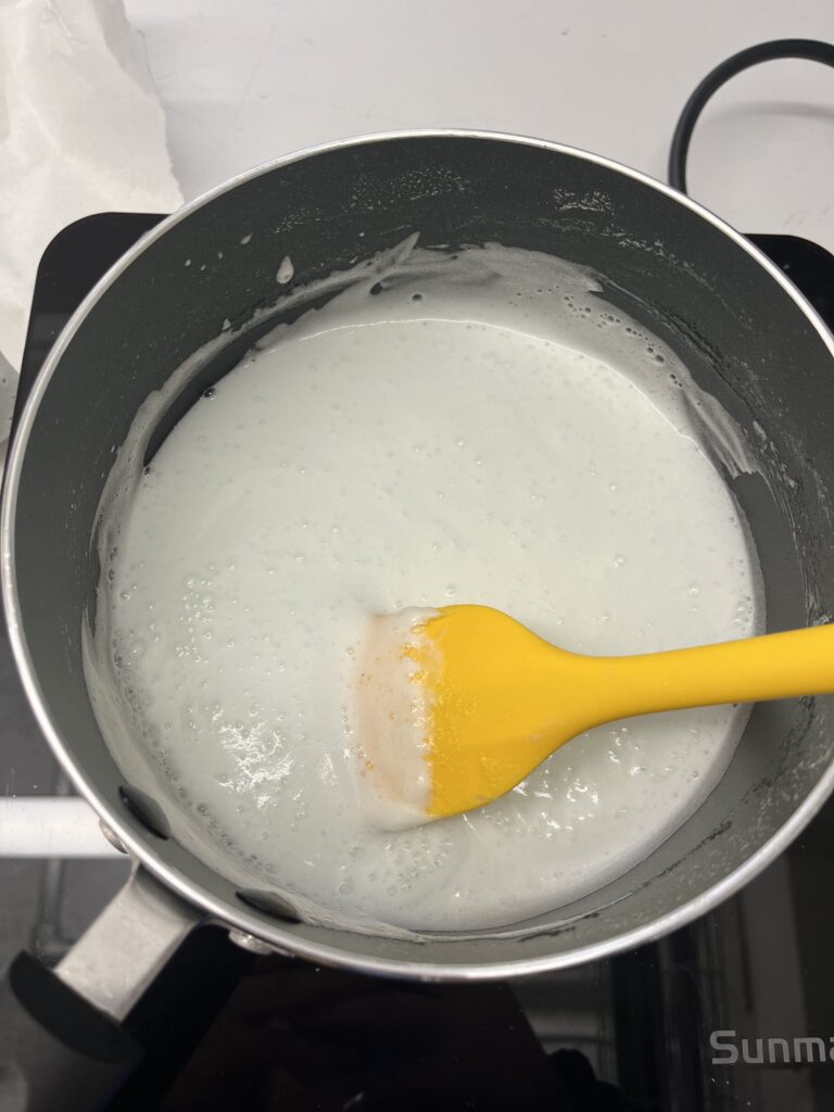 Marshmallow-y biofoam mixture in pot on top of hotplate.