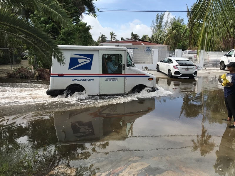 A FedEx truck driving through a flooded street in Florida