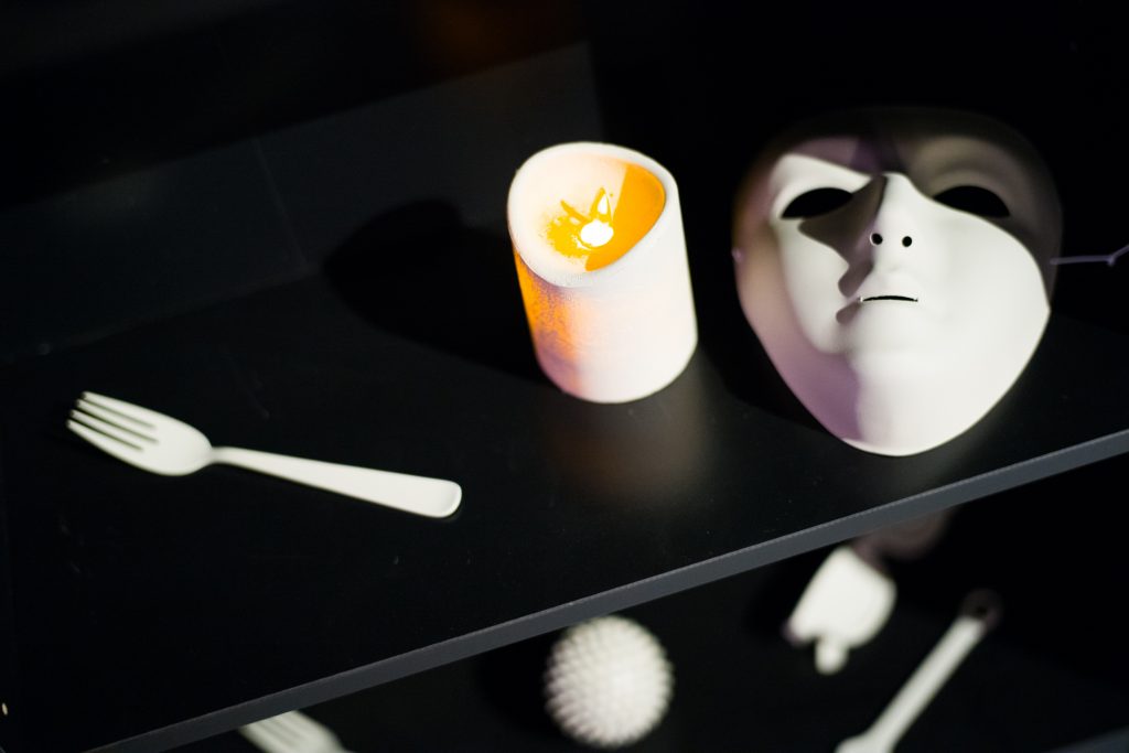 3D-printed objects including a fork, candle, and a mask