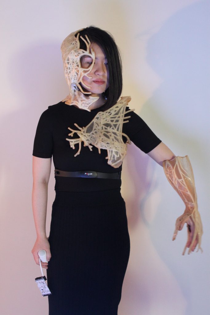 Figure 1. A model wearing three architectural devices on the face, shoulder and forearm. Each made from scoby based biomaterials.