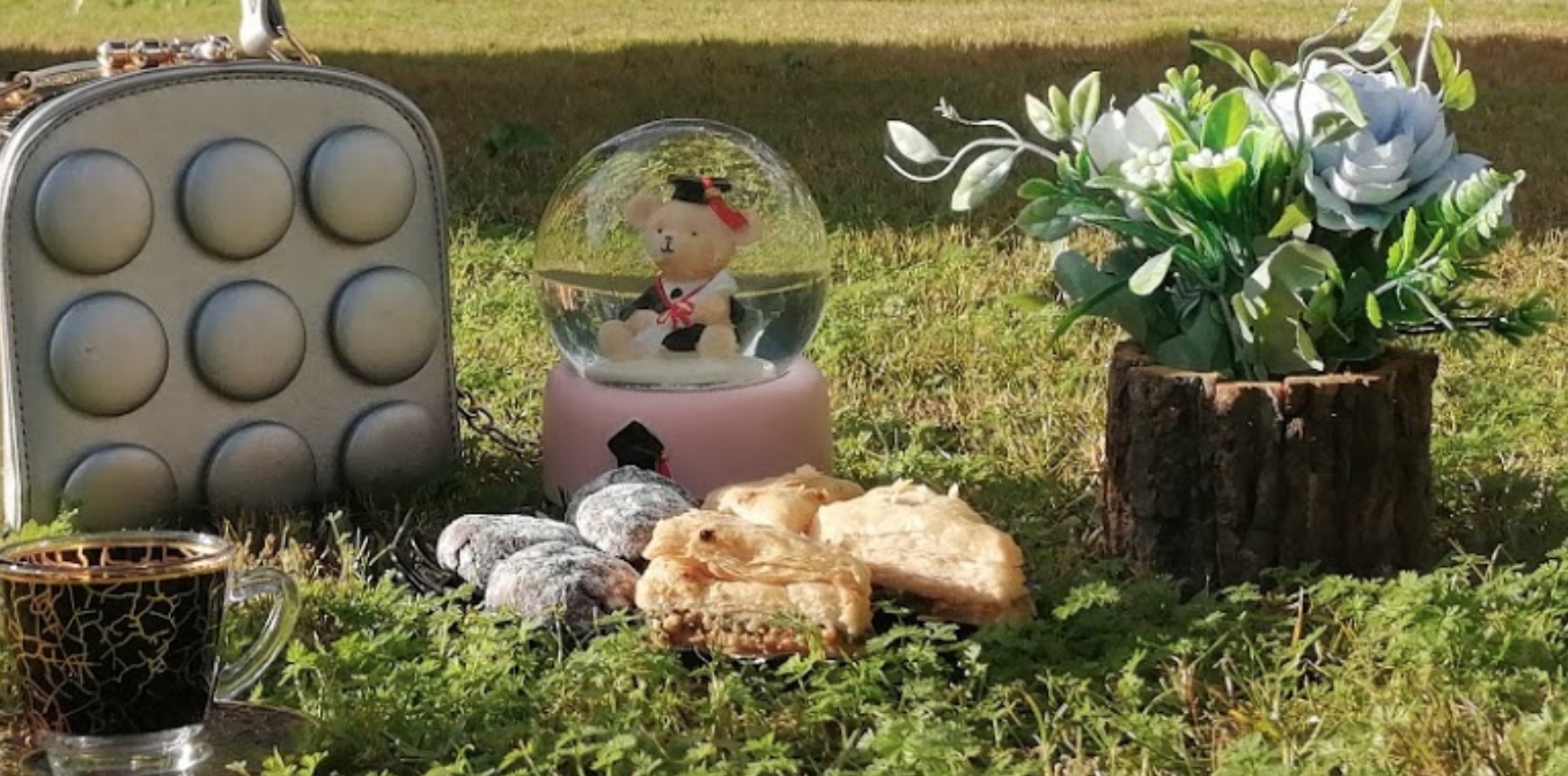 Promotional image from a seaside hotel in Libya. It is set up as a picnic photo but looks like an altar, especially with pastries directly on the ground.