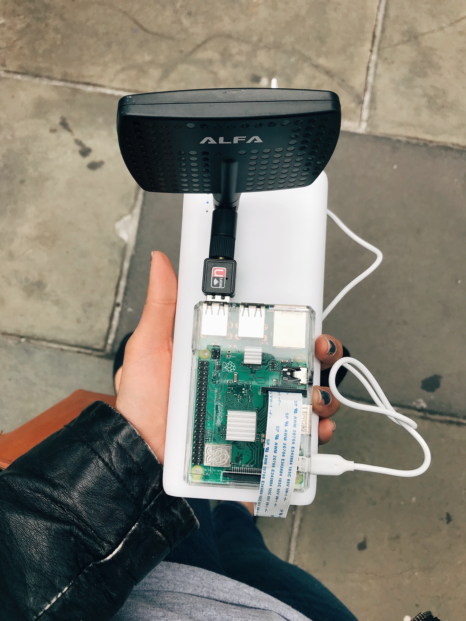 A Raspberry Pi, with attached WiFi antenna and portable battery pack.