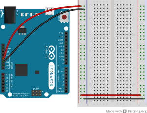 An Arduino Leonardo on the left connected to a solderless breadboard, right. The Leonardo's 5V output hole is connected to the red column of holes on the far left side of the breadboard. The Leonardo's ground hole is connected to the blue column on the left of the board. The red and blue columns on the left of the breadboard are connected to the red and blue columns on the right side of the breadboard with red and black wires, respectively. These columns on the side of a breadboard are commonly called the buses. The red line is the voltage bus, and the black or blue line is the ground bus.