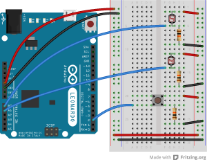 Breadboard drawing of an Arduino Leonardo connected to a pushbutton and two voltage divider inputs. The pushbutton is connected as described in the previous breadboard drawing. Two photoresistors are mounted in the right center section of the breadboard. The first is connected to rows 2 and 5. The second is connected to rows 11 and 14. Rows 2 and 11 are also connected to the right side voltage bus through red wires. Two 10-kilohm resistors are also mounted in the right center section. The first is connected to rows 5 and 9, and the second is connected to rows 14 and 18. Rows 9 and 18 are connected to the right side ground bus. The four resistors thus form two voltage dividers. A blue wire extends from the middle of each divider to the analog pins. The first goes from row 5 to pin A0, and the second from row 14 to pin A1.