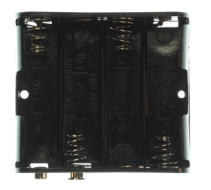 This is a square box that can hold four AA size batteries. There are four columns in the box, each with a spring in it. The negative end of the battery (the flat end) contacts the spring. The positive end of the battery (the end with a small protrusion) connects to the end opposite the spring. The batteries sit parallel to each other, each facing the opposite direction of its neighbors. Two round metal terminals protrude from one corner of the box, one red and one black. These connect to a 9-volt battery