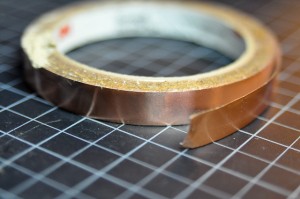 Photo of a roll of copper tape, approximately 1cm thick. This tape is made of thin copper and has an adhesive backing.