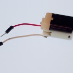 DC toy motor, hobby size. This motor is a metal tube with flattened sides, approximately 2 in. (5cm) long. a thin shaft at one end spins when the motor is on. Two small metal tabs or wires protrude from the other end to connect the motor to your circuit.