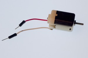 DC toy motor, hobby size. This motor is a metal tube with flattened sides, approximately 2 in. (5cm) long. a thin shaft at one end spins when the motor is on. Two small metal tabs or wires protrude from the other end to connect the motor to your circuit.