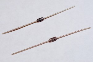 Diodes. Shown here are 1N400x power diodes. The body of the component is black, and the end is silver. The silver end indicates the cathode end of the diode.