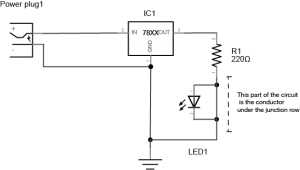 Schematic image of a 220-ohm resistor and an LED connected to a 7805 5-volt regulator. At left, there is a power plug. The positive terminal of the power plug is connected to the voltage input of a 7805 voltage regulator. The negative terminal of the power plug is connected to the ground terminal of the regulator. The voltage output of the regulator is connected to a 220-ohm resistor. The other side of the resistor is connected to the anode of an LED. The cathode of the LED is connected to the ground terminal of the regulator. The LED is bypassed by a wire, however, so the current bypasses the LED entirely. 