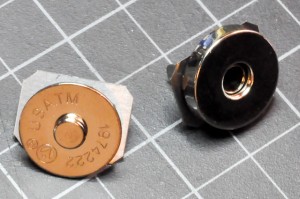 Photo of magnet snaps. Two metal discs approx 1 inch (2.54cm) in diameter. One has a metal protrusion in the center, and the other has a depression that can fit the other's protrusion. Wires can be connected to the two snaps so that when they are snapped together, the wires are connected.