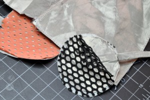 Photo of three pieces of conductive fabric. Two of the pieces have non-conductive layers on top of them.