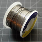 Photo of a roll of solder wire. The wire is thin, approximately 0.05 inches (1mm) in diameter. It is quite soft, and breaks easily. 
