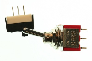 Toggle switches. These switches are approximately half an inch (1cm) long, and have a switch on top that moves from one side to the other. They typically have two or three legs. 