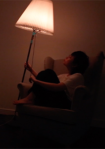 person in armchair with a lamp