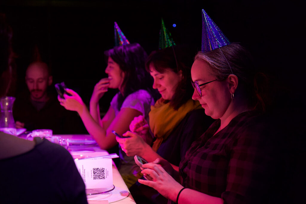 There guests in party hats are engaged Reintegration Training survey on their phones.