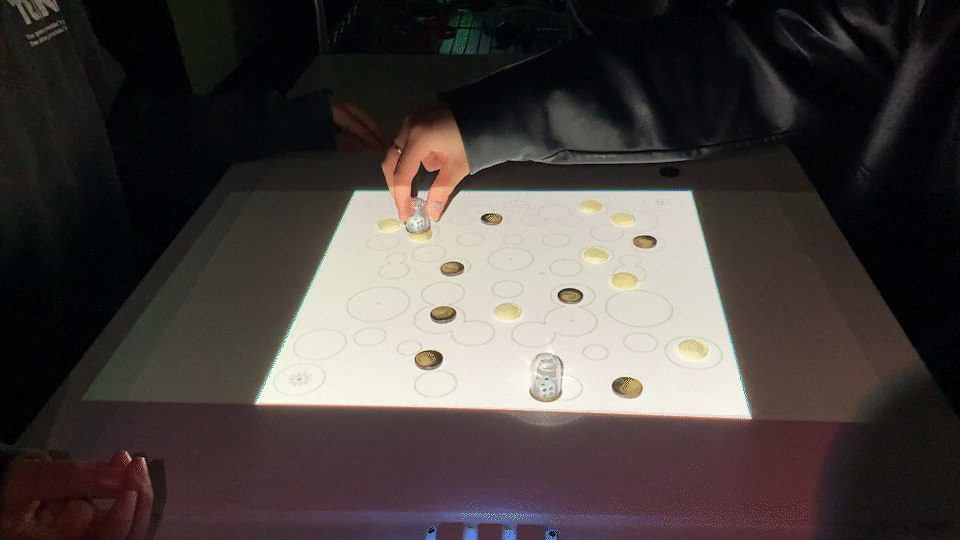 Players playing a video projected on top of game board with game pieces
